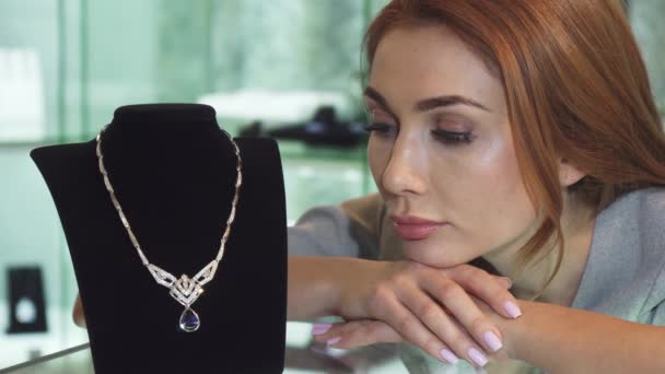 Mujer triste posando con un costoso collar de diamantes en la tienda — Vídeos de Stock