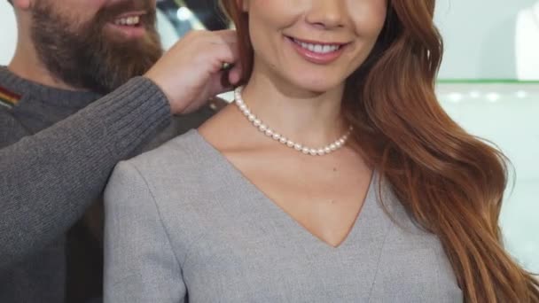 Beskuren bild av en man justera pärlhalsband på halsen av sin fru — Stockvideo