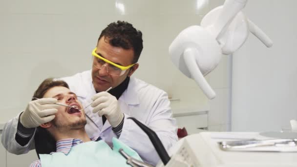 Profissional maduro dentista masculino realizando exame odontológico — Vídeo de Stock