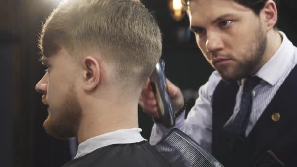 Nahaufnahme eines gutaussehenden professionellen Friseurs stylische Haare eines Mannes — Stockvideo