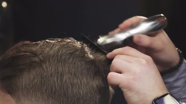 Nahaufnahme eines Friseurs, der seinem Kunden mit einem Trimmer die Haare schneidet — Stockvideo