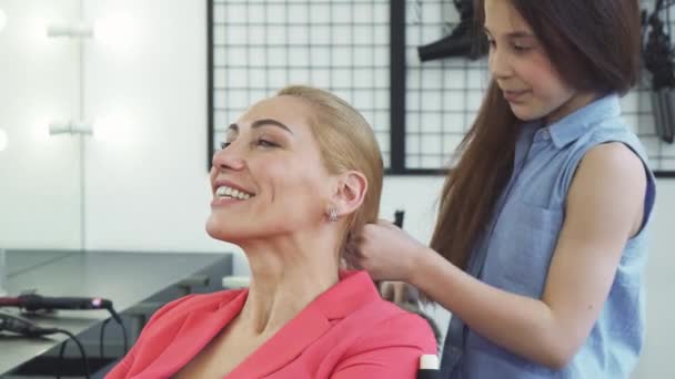 Linda mulher feliz gostando de obter um novo penteado por sua filha bonito — Vídeo de Stock