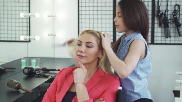 Mulher bonita alegre sorrindo enquanto sua filha pentear o cabelo — Vídeo de Stock