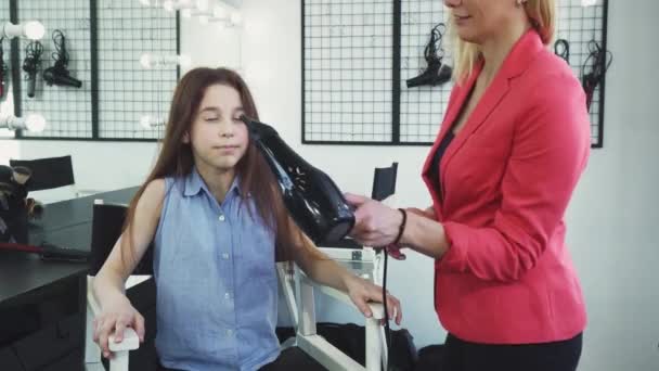 Boldog kis lány élvezi a haját lét szárított-által a szalonban fodrászat — Stock videók