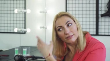 Olgun kadın saçlarını split uçları ile inceleyerek üzgün seyir