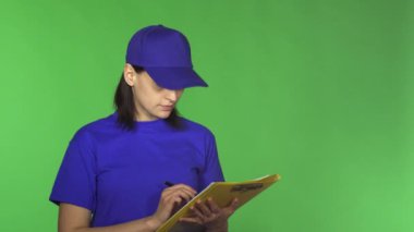 Genç teslimat kadın kameraya gülümseyen bir Pano kağıtlara kontrol