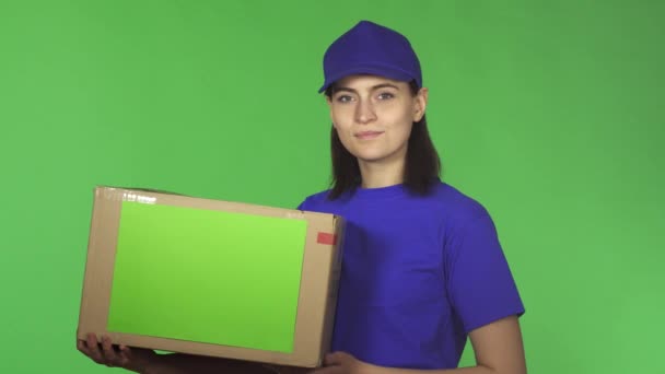 Atractiva joven partera mostrando los pulgares hacia arriba sosteniendo la caja de cartón — Vídeos de Stock