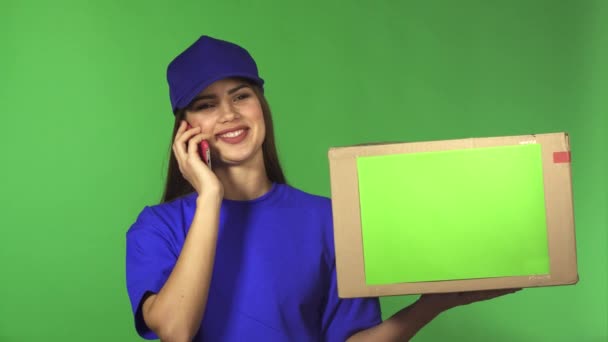 Nádherné ženské dodání služby pracovník přináší balíček mluvil po telefonu — Stock video
