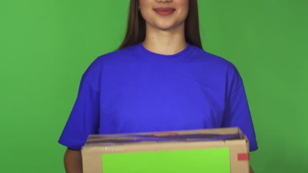 Holding carboard gülümseyen bir teslimat kadının kırpılmış atış ile boşaltmak kutu — Stok video