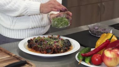 Bir kadının evde pişirme yeşillik ile lezzetli yemek süsleme kadar kırpılmış clsoe