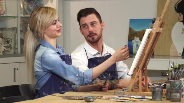Liebendes junges Paar genießt die gemeinsame Arbeit an einem Gemälde im Kunstatelier