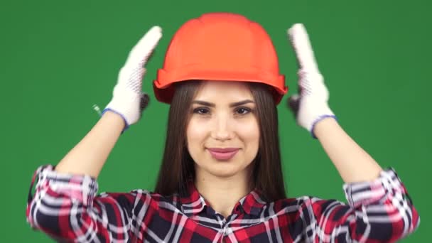 Giyen hardhat gülümseyen bir seksi güzel kadın constructionist yakın çekim — Stok video