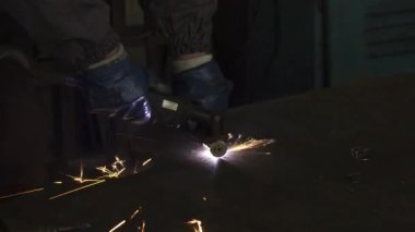 Kırpılan atış etrafta uçuşan kıvılcımlar ile bir fabrika işçisi kesme çelik