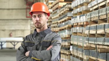 Yakışıklı bir ciddi metalworker fabrika depolama vasıl poz portresi