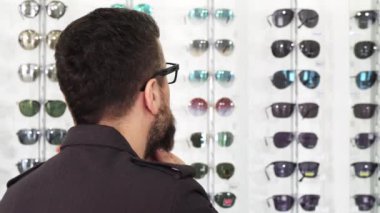 Shop güneş gözlüğü seçtiğiniz bir dountful adam görüntüsünü kapatmak
