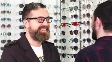 Olgun erkek müşteri için optometrist yeni gözlük seçerken konuşuyor