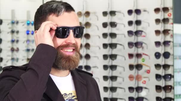 Cheerful mature man smiling to the camera while buying sunglasses — Stock Video