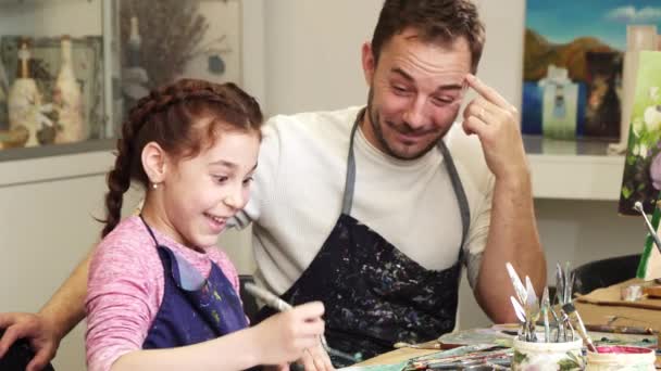 Lykkelig far som tar bilder av sin søte lille datter mens hun tegner – stockvideo