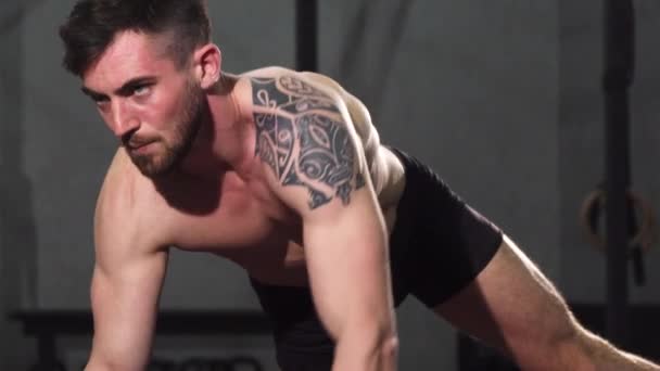 筋肉の刺青男がジムでワークアウトをリッピング — ストック動画
