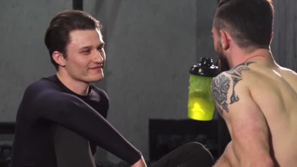 Jovem atleta masculino conversando com seu amigo no ginásio — Vídeo de Stock