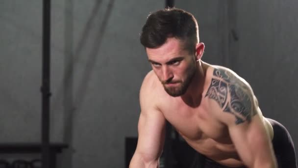 Atleta masculino sin camisa joven enfocado haciendo ejercicio de vuelta en el gimnasio — Vídeo de stock