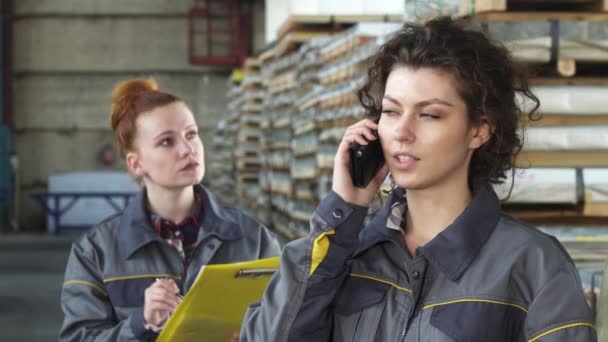 Mooie gelukkig vrouwelijke fabrieksarbeider praten aan de telefoon — Stockvideo