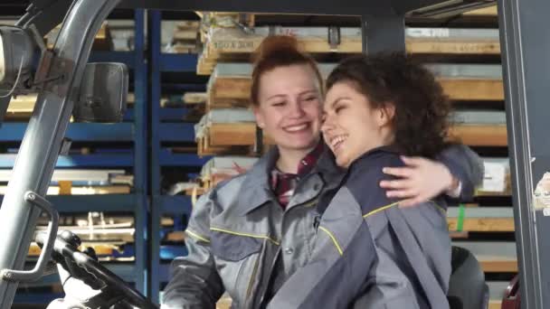Zwei fröhliche Fabrikarbeiterinnen umarmen sich glücklich lächelnd in die Kamera — Stockvideo