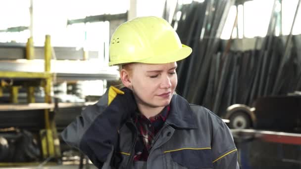 Уставшая работница фабрики снимает каску после работы — стоковое видео