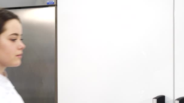 Женщина-повар улыбается камере во время работы на своей кухне — стоковое видео