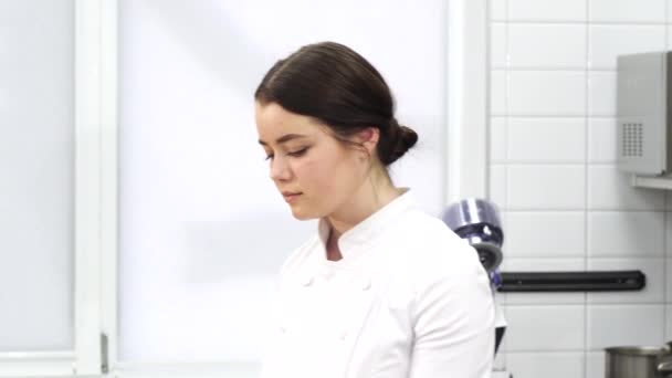 Chef pastelero profesional sonriendo sosteniendo una bandeja llena de deliciosos macarrones — Vídeos de Stock