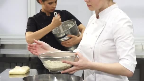 Молодая привлекательная женщина-повар улыбается в камеру во время приготовления пищи — стоковое видео