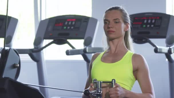 Spor salonunda egzersiz kürek kablo yapıyor güzel sporcumuz oturmuş — Stok video