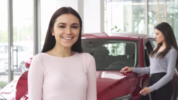 Araba anahtarları tutan yukarı başparmak gösterilen neşeli genç kadın — Stok video