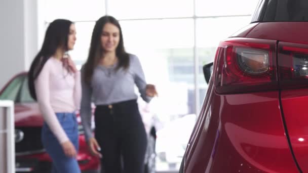 Deux femmes discutent d'une nouvelle voiture au showroom du concessionnaire — Video