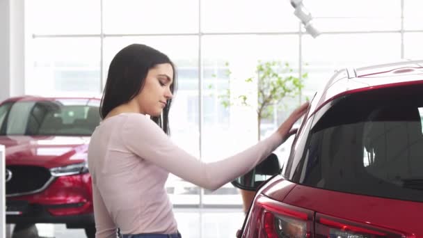 在汽车经销处使用智能手机的快乐女人 — 图库视频影像