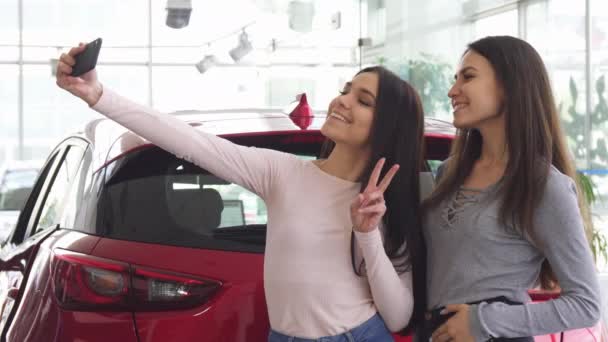 Alegres amigas tomando selfies cerca del coche nuevo — Vídeo de stock