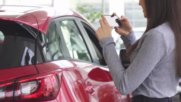 Beskuren bild av en kvinna som tar bilder av hennes nya bil — Stockvideo