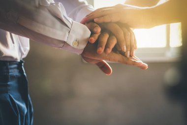 Bir yığın insan eli, iki insan ellerini birleştiriyor.