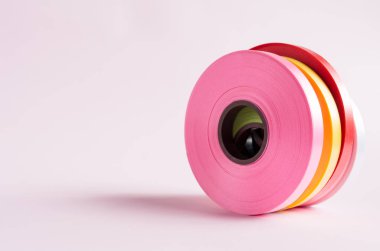 Pembe arkaplanda renkli kurdele rulosu 