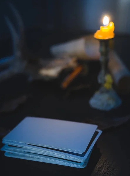 低调静谧的生活摄影 空白的塔罗牌在桌子上的黑暗色调和烛台的光芒 — 图库照片#