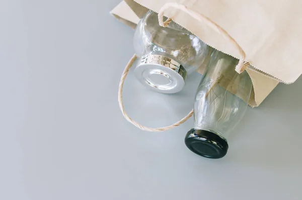 paper bag and glass wares on grey background, no plastic packages, zero waste concept