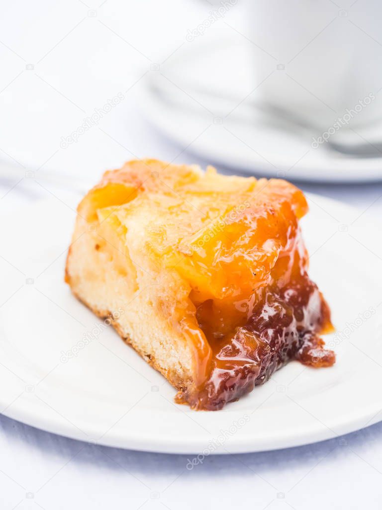 Slice of typical pineapple cake from Azores on white plate 