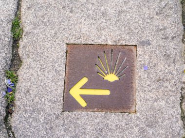 The yellow scallop shell signing the way to Santiago de Compostela in Porto, on the Saint James pilgrimage route clipart