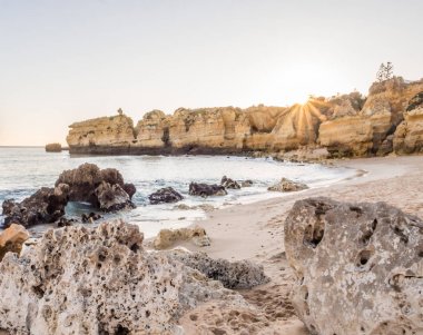 güzel kayalık Sao Rafael Beach'te günbatımı zamanı Portekiz Algarve bölgesinde temiz mavi su ile. 