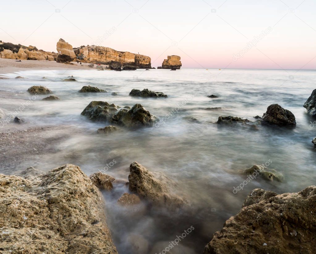 beautiful rocky Sao Rafael beach in sunset time with clean blue water in Algarve region, Portugal. 