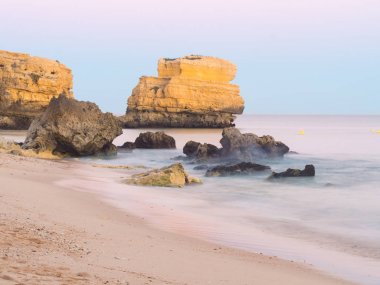 güzel bir kayalık Sao Rafael plaj günbatımı zamanı, Portekiz Algarve bölgesinde temiz mavi su ile. 