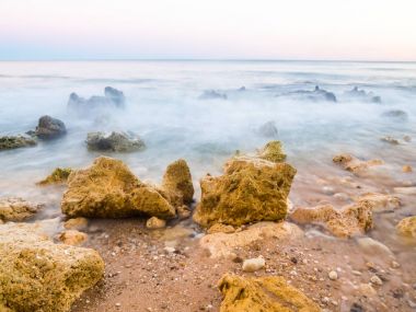 güzel bir kayalık Sao Rafael plaj günbatımı zamanı, Portekiz Algarve bölgesinde temiz mavi su ile. 
