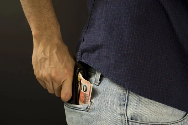 M-cüzdan ile iç cebinde Brezilya para koyarak adam
