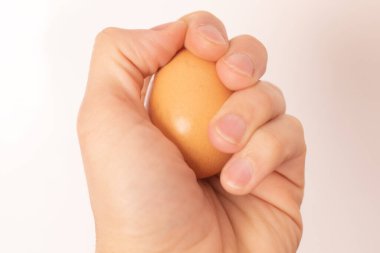 Mano agarando huevo ayık fondo blanco