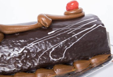 Tarta brazo gitano de çikolata sobre fondo blanco